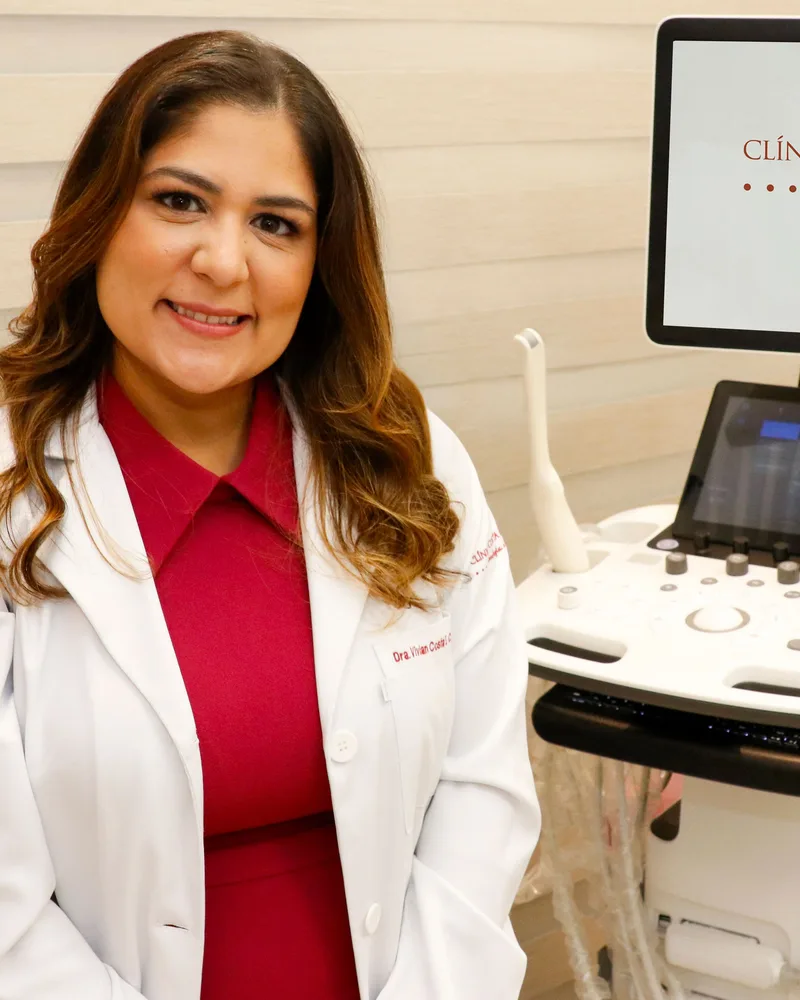 Dra. Vívian Costa ao lado do aparelho de ultrassom da clínica